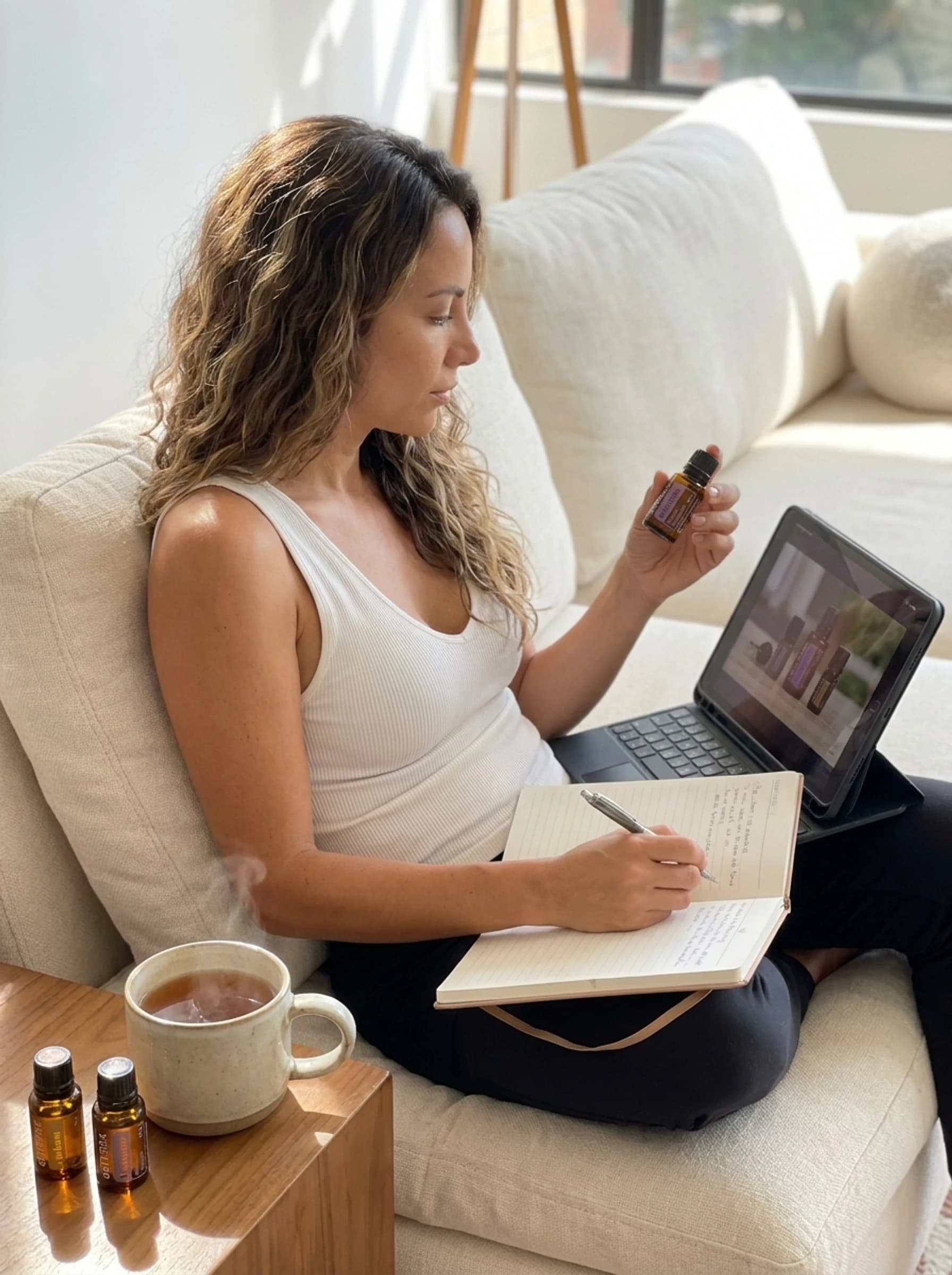 Aprendizaje virtual desde casa con un aceite esencial doTERRA, una tableta y un cuaderno